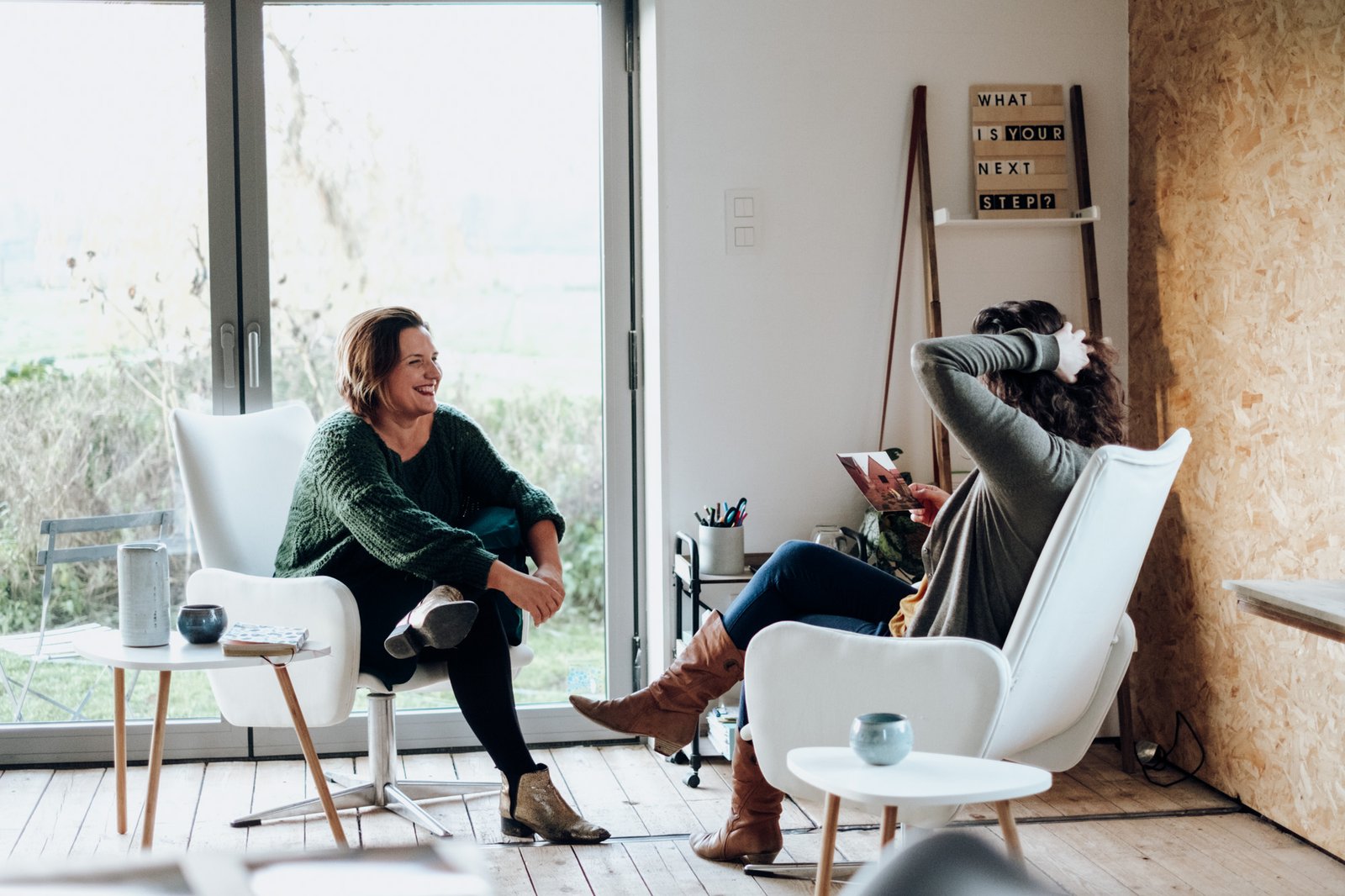 Ida in gesprek met twee mannen, ontspannen zittend bij het raam