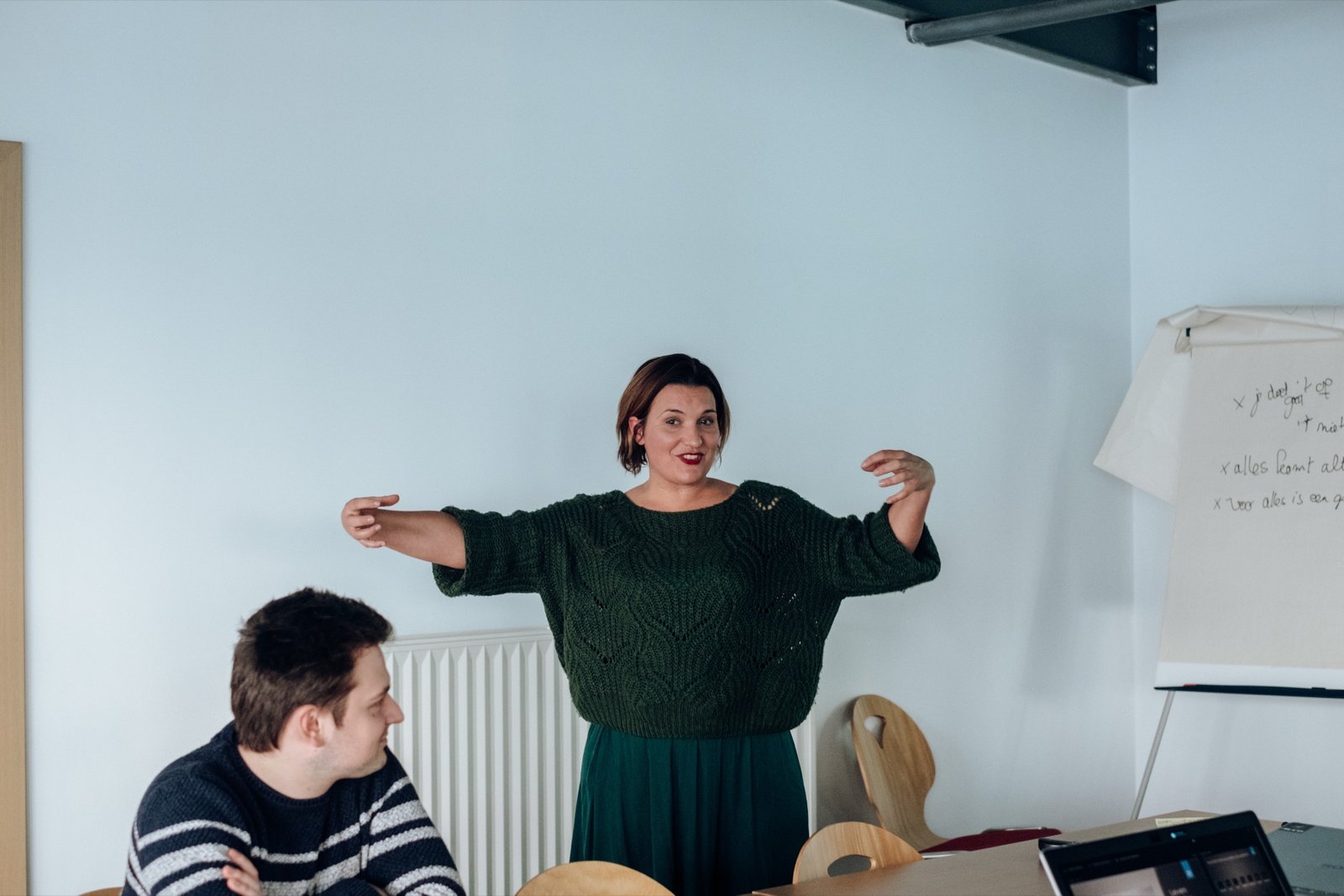 Ida geeft les, armen gespreid, in gesprek met een deelnemer