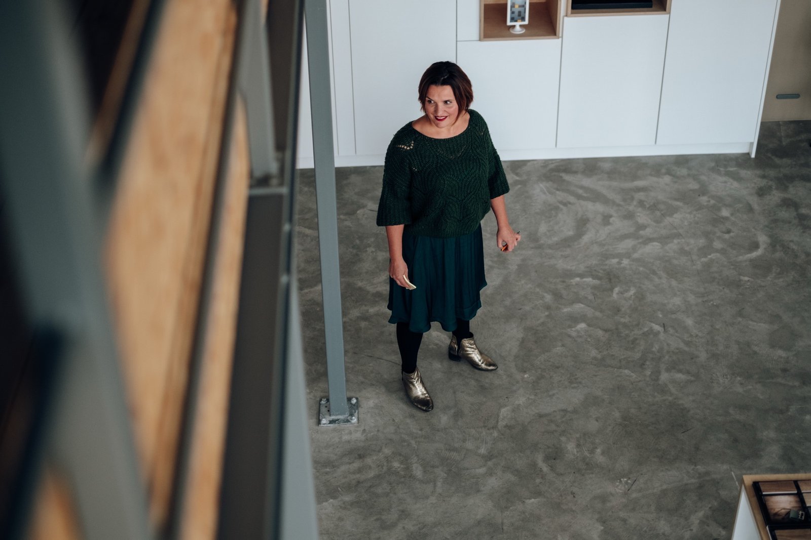 Ida van bovenaf gefotografeerd, lachend in een lichte ruimte