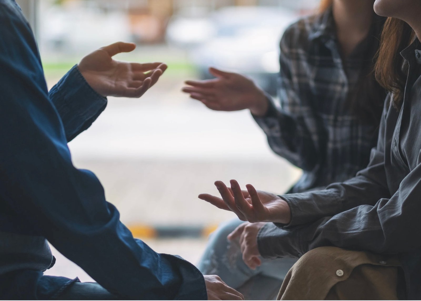 Groep mensen in gesprek, handen zichtbaar, gebaren tijdens gesprek